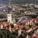 A medieval wall borders an old seaside town from a forested area